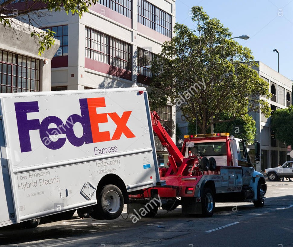 a-fedex-express-hybrid-electric-delivery-van-being-towed-by-a-tow-B8RG8K~2.jpg